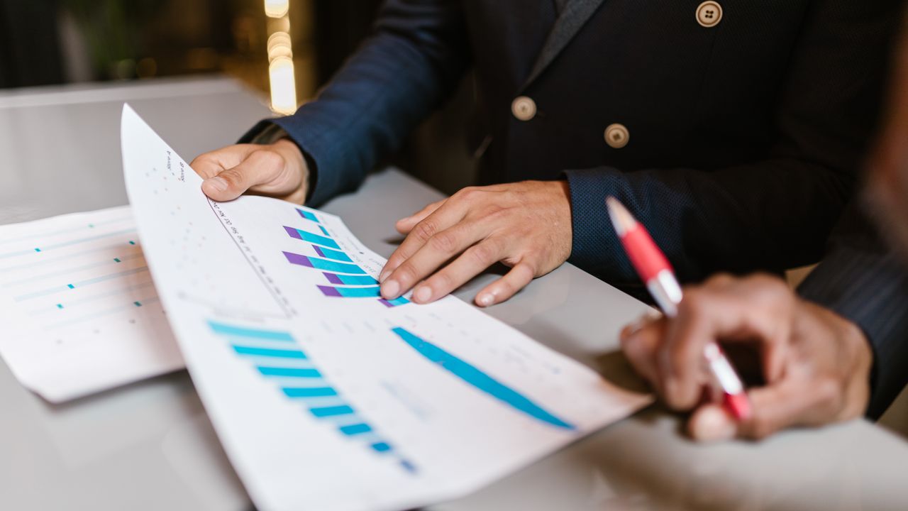 Marketing team reviewing customer acquisition cost figures on a dashboard