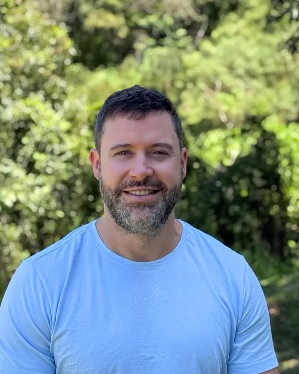 Diego Zietek smiling outdoors, trees behind him