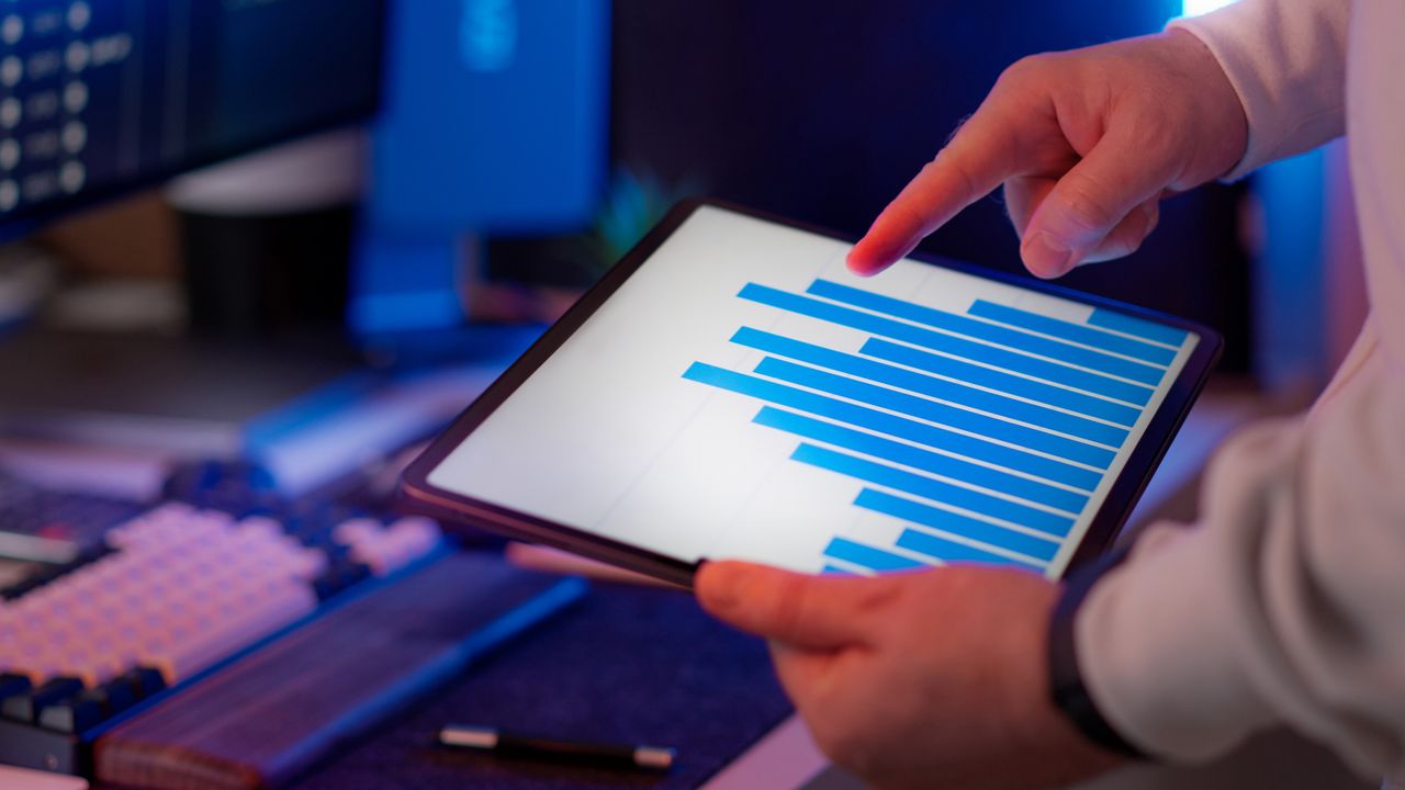 A small business owner reviewing advertising results on a tablet at a work desk