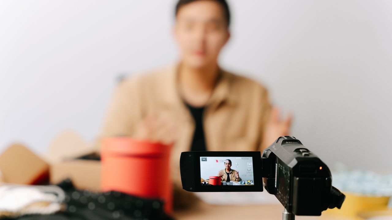 A content creator filming a product video with a smartphone, the kind of paid post that needs a clear advertising disclosure